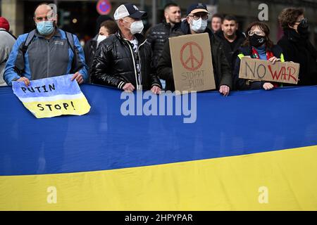 Köln, Deutschland. 24th. Februar 2022. Demonstranten stehen in einer Menschenkette mit ukrainischer Flagge. Mehrere hundert Menschen demonstrieren auf dem Neumarkt gegen den Angriff Russlands auf die Ukraine. Quelle: Federico Gambarini/dpa/Alamy Live News Stockfoto