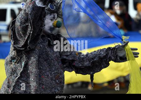 Köln, Deutschland. 24th. Februar 2022. Ein Clown spielt mit Tüchern in den ukrainischen Farben. Mehrere hundert Menschen demonstrieren auf dem Neumarkt gegen den Angriff Russlands auf die Ukraine. Quelle: Federico Gambarini/dpa/Alamy Live News Stockfoto