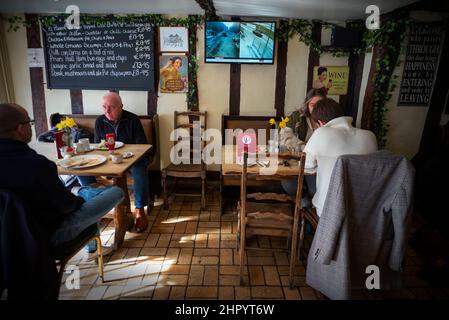 Russland erobert die Ukraine, im Fernsehen in der Weinbar Thaxted Essex, Großbritannien. 24th. Februar 2022. Während Kunden der Parrishes Wine Bar in Thaxted Essex UK ihr Mittagessen einnehmen, zeigt das Fernsehgerät Berichte auf der BBC, die die Invasion der Ukraine durch Russland heute zeigen. Kredit: BRIAN HARRIS/Alamy Live Nachrichten Stockfoto