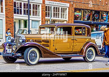 11-20-2021 Tulsa USA -19302 Cadillac Series 355C Steampunk-Limousine mit einem jungen Mann, der auf der Straße im Arts District Tulsa ein Videotaping-Rad dreht Stockfoto