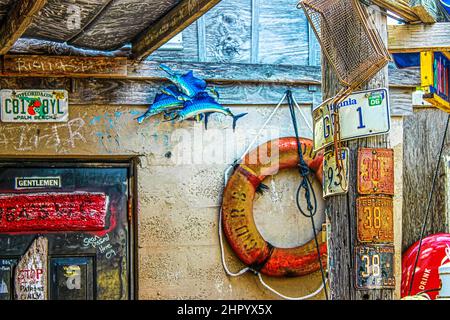 2010-07-22-Key West Florida USA - Außen Gentlemen Badezimmer in Bos Fish Shack -gungy Dekor einschließlich Nummernschilder Fisch braten Korb Life Ring Boje Stockfoto