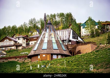 Chalets und Häuser mit Blick auf den Crested Butte Mountain Colorado USA im Sommer - konisches Haus mit Fenstern auf dem Dach im Vordergrund und Espe Stockfoto