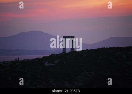 Panorama des dramatisch bunten Sonnenuntergangs über den Ruinen des antiken Tempels von Apollo, Naxos, Griechenland. Beachten Sie, dass die entfernten Menschen nicht erkennbar sind. Stockfoto