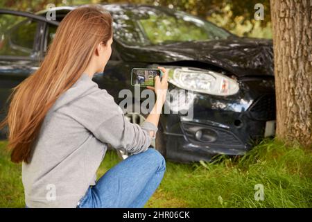 Frau Steigt Aus Dem Rauchenden Auto Und Macht Foto Von Unfallschäden Auf Dem Mobiltelefon Stockfoto