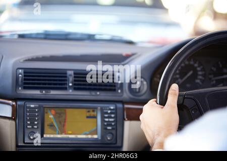 Ihr Ziel erwartet Zugeschnittenes Bild eines gps-Navigationssystems und eines mans Hände auf dem Lenkrad eines Autos. Stockfoto