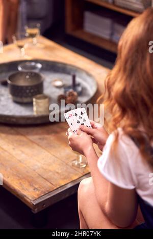 Nahaufnahme Einer Frau Zu Hause, Die Karten Mit Freunden Auf Der Games Night Spielt Stockfoto