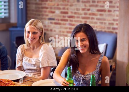 Zwei Weibliche Freunde Genießen Gemeinsam Mit Freunden Ein Takeaway-Essen Zu Hause Stockfoto