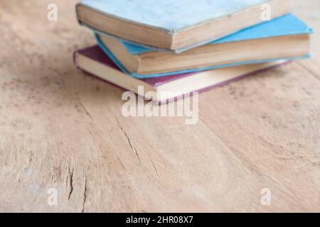 Bücher, Haufen von Hardcover-Büchern auf dem Holztisch mit selektivem Fokus. Verschwommene Bücher als Bildungshintergrund mit Kopierraum. Bildung oder Literat Stockfoto