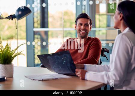 Ärztin Diskutiert Scan-Ergebnisse Mit Lächelndem Männlichen Patienten Im Krankenhaus Stockfoto