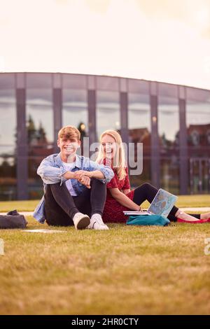Männliche Und Weibliche Studenten Der Universität Oder Der Hochschule Sitzen Im Freien Auf Dem Campus Und Reden Und Lachen Stockfoto