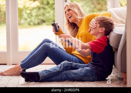 Mutter Und Sohn Zu Hause Spielen Videospiel Zusammen Mit Frau Betrügen, Um Zu Gewinnen Stockfoto