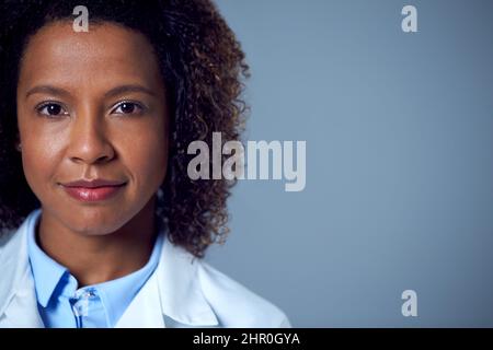 Studio Portrait Einer Lächelnden Ärztin Oder Laborarbeiterin In Weißem Mantel Stockfoto