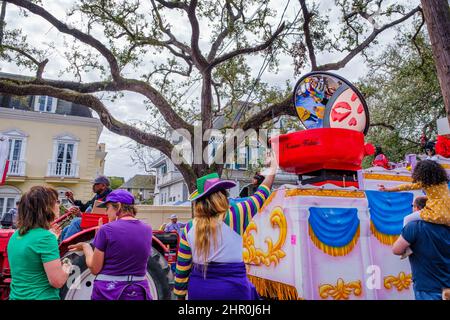 NEW ORLEANS, LA, USA - 20. FEBRUAR 2022: Paradebeobachter in Mardi Gras-Kleidung fordern Perlen von Festwagen-Fahrern der Femme Fatale Parade auf St. Char an Stockfoto
