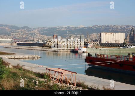 Ein Blick auf den Hafen mit den ikonischen verwüsteten Getreidesilos, Beirut, 23. Februar 2022. Die fast 50 Meter hohen Silos waren mit einer Kapazität von rund 100,000 Tonnen Getreide die größten des Landes. Sie schützten ganze Nachbarschaften vor der Explosion. Während die libanesische Regierung bis Ende des Monats Angebote für Unternehmen zum Abriss der Silos eröffnen wird, kämpfen Familien der Opfer von Sprengsätzen gegen ihren Abriss. In den sozialen Medien beschuldigen sie die Regierung, „die Zeugen getötet zu haben“, während die Verantwortlichen auf freiem Fuß sind. Den Familien der Opfer zufolge versucht die Regierung, „sie zu waschen Stockfoto