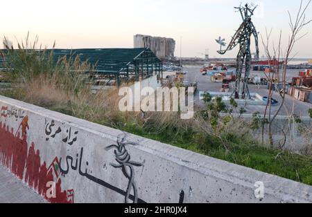 Ein Blick auf den Hafen mit den ikonischen verwüsteten Getreidesilos, Beirut, 23. Februar 2022. Die fast 50 Meter hohen Silos waren mit einer Kapazität von rund 100,000 Tonnen Getreide die größten des Landes. Sie schützten ganze Nachbarschaften vor der Explosion. Während die libanesische Regierung bis Ende des Monats Angebote für Unternehmen zum Abriss der Silos eröffnen wird, kämpfen Familien der Opfer von Sprengsätzen gegen ihren Abriss. In den sozialen Medien beschuldigen sie die Regierung, „die Zeugen getötet zu haben“, während die Verantwortlichen auf freiem Fuß sind. Den Familien der Opfer zufolge versucht die Regierung, „sie zu waschen Stockfoto