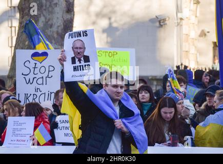 London, Großbritannien. 24.. Februar 2022. Ein Protestler hält ein Plakat, das Putin mit Hitler vergleicht. Demonstranten versammelten sich vor der Downing Street, um gegen die russische Invasion in der Ukraine zu protestieren und riefen die britische Regierung dazu auf, der Ukraine zu helfen und zusätzliche Sanktionen gegen Russland zu verhängen. Kredit: Vuk Valcic/Alamy Live Nachrichten Stockfoto