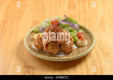 Japanisches Essen frittiertes Huhn Tori Karaage in einem Holzteller isoliert auf Holzhintergrund Draufsicht Stockfoto