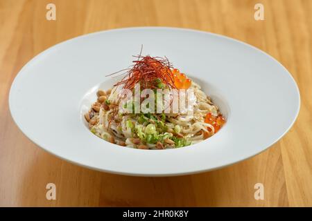 japanische Küche Trüffel Udon in Gericht isoliert auf Holzhintergrund Draufsicht Stockfoto