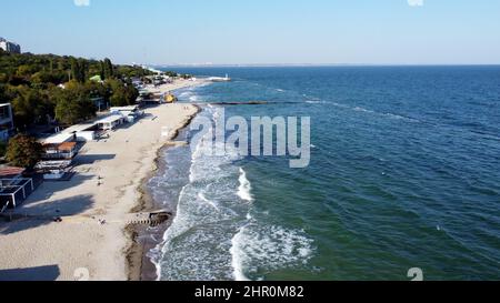 Menschen, die am sonnigen Tag am Strand spazieren und sich entspannen. Lufttrohnenansicht Flug Über Stockfoto