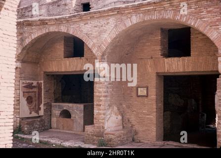 Ostia Antica - große archäologische Stätte in Arbeit, Lage der Hafenstadt des alten Rom. Via della Casa di Diana Thermopolium. Archivscan von einem Dia. April 1970. Stockfoto