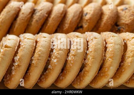 Knusprige Shortbread Zucker Kekse Makro Hintergrund. Eine Reihe leckerer Butterkekse mit Zucker aus der Nähe. Textur von gebackenem Gebäck zum Frühstück. Süßes Essen. Stockfoto