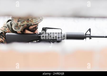 Scharfer Shooter. Profil eines Soldaten, der eine Waffe mit einem Schlitz im Vordergrund anvisieren soll. Stockfoto