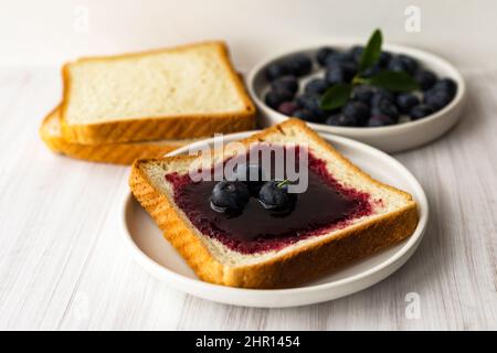 Heidelbeermarmelade Brot Toast und frische Beeren auf dem Teller. Gesundes Frühstückskonzept Stockfoto