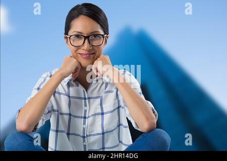 Zusammengesetztes Bild des Porträts einer afroamerikanischen Frau, die im Hintergrund vor hohen Gebäuden lächelt Stockfoto