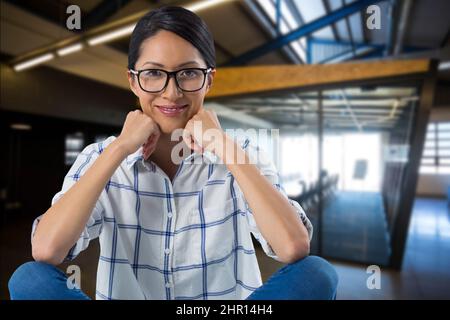 Zusammengesetztes Bild des Porträts einer afroamerikanischen Frau, die vor einem leeren Büro im Hintergrund lächelt Stockfoto