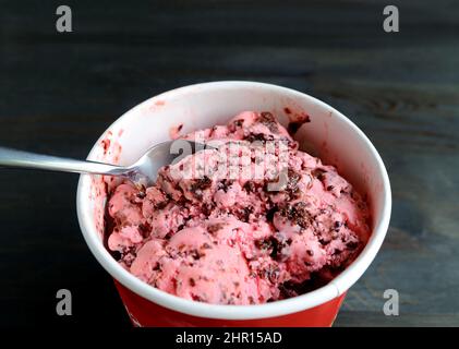 Löffel, der das köstliche Erdbeer-Schokolade-Chunk-Eis ausschaufelt Stockfoto