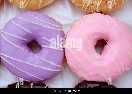 Nahaufnahme von köstlichen pastellfarbenen glasierten Donuts Stockfoto