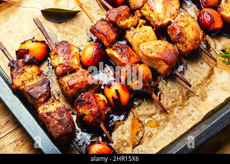 Gebratenes Fleisch auf Holzspießen.leckere Kebabs in Pflaumensoße Stockfoto