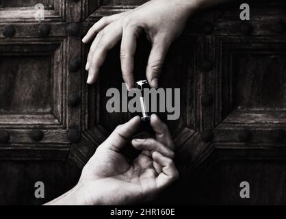 Zusammenfügen der Teile. Zwei Hände beim Verschrauben einer Mutter und des Verschraubens. Stockfoto