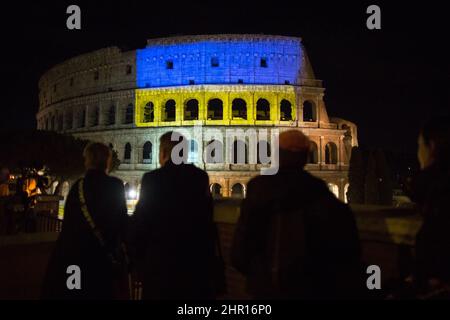 Rom Roma, Italien Italia. 24.. Februar 2022. Rom, 24.. Februar 2022. Die ukrainische Flagge wurde auf die Wände des Kolosseums in Rom projiziert, wo sich Menschen aus der ukrainischen Gemeinschaft versammelten, um ihre Fahnen zu schwingen, um gegen den Krieg gegen die Ukraine zu protestieren, der heute Morgen vom russischen Präsidenten Wladimir Putin erklärt wurde. Kredit: LSF Foto/Alamy Live Nachrichten Stockfoto