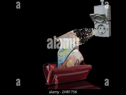 Eine Steckdose, die Geld aus einem Geldbeutel saugt. Wie teuer wird Energie sein? Steigende Energiepreise belasten die monatlichen Einkommen der Verbraucher. Stockfoto
