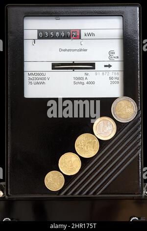 Stromzähler mit aufsteigenden Euro-Münzen von 10 Cent auf 2 Euro. Die Preise für Gas, Strom und Benzin steigen rasant. Stockfoto
