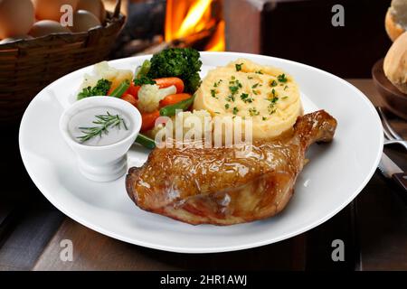 Gebratene Hühnerschenkel mit Gemüse und Kartoffelpüree Stockfoto