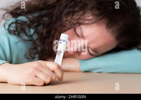 Frau zeigt einen schnellen COVID-19-Test zur Diagnose einer neuen Corona-Virusinfektion (neue Corona-Viruserkrankung 2019 oder COVID). Pandemisches Infektionserkonzept Stockfoto