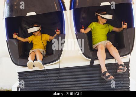 Die kleinen Jungen spielen das Spiel in Virtual-Reality-Brillen im Freien Stockfoto