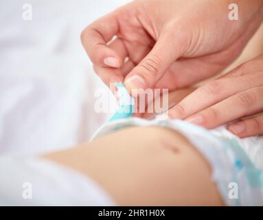 Alle in einem Tag arbeiten für eine Mutter. Zugeschnittenes Bild einer Mutter, die ihre Babywindel wechselt. Stockfoto