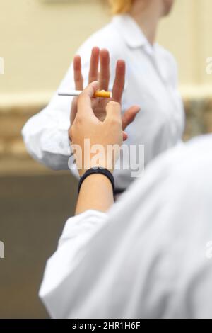 Nein sagen Kurzer Schuss einer jungen weiblichen Studente, die als Reaktion auf den Druck von Kollegen Zigaretten abdrehte. Stockfoto