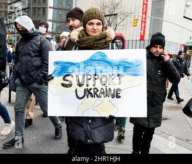 New York, Usa. 24th. Februar 2022. Frau hält ein Schild mit der Aufschrift „unterstützt die Ukraine“ bei einer Kundgebung „Stoppt Putin“, die als Reaktion auf den Krieg in der Ukraine organisiert wurde. Kredit: SOPA Images Limited/Alamy Live Nachrichten Stockfoto