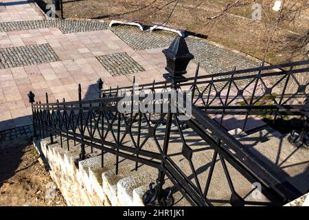 Schützendes schwarzes Geländer auf den Stufen, die am sonnigen Frühlingstag im Park hinaufführen Stockfoto