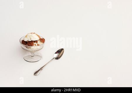 Closeup Glas Podest Gericht mit Eis Aromen und Löffel in einer Bank von frischem weißen Schnee gelegt. In der Ecke festgelegte Objekte bieten einen großen Textraum. Stockfoto