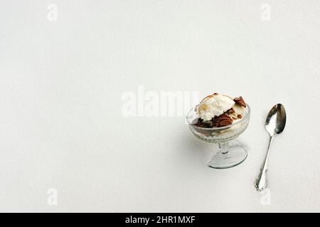 Closeup Glas Podest Gericht mit Eis Aromen und Löffel in einer Bank von frischem weißen Schnee gelegt. In der Ecke festgelegte Objekte bieten einen großen Textraum. Stockfoto