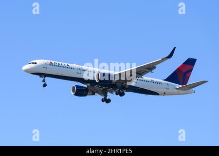 SeaTac, WA, USA - 23. Februar 2022;Delta Air Lines boeing 757 landet isoliert gegen blauen Himmel mit Rädern nach unten Stockfoto