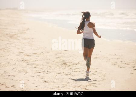 Wenn deine Beine müde werden, Lauf mit deinem Herzen. Aufnahme einer sportlichen jungen Frau, die im Freien trainiert. Stockfoto