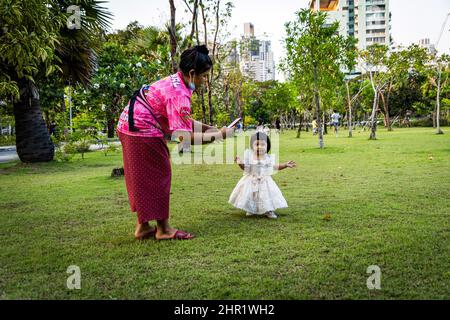 Bangkok, Thailand. 25.. Februar 2022. Eine Mutter spielt mit ihrem Kind in einem Outdoor-Park in Bangkok. Das tägliche Leben in Bangkok, während sich Thailand darauf vorbereitet, die Anforderungen für das „Test and Go“-Programm zu lockern, dessen Quarantäne-freies Eintrittsprogramm für vollständig geimpfte internationale Touristen. Die Einreisebestimmungen werden gelockert, da das Land einen Anstieg der COVID-19-Infektionen verzeichnet, der durchschnittlich über 20.000 gemeldete Fälle pro Tag umfasst. Kredit: SOPA Images Limited/Alamy Live Nachrichten Stockfoto