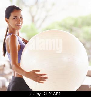 Bereit für den Ball. Porträt einer schönen jungen Frau, die zu Hause einen Übungsball hält. Stockfoto