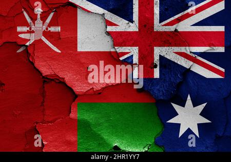 Flaggen von Oman und Australien auf rissige Wand gemalt Stockfoto
